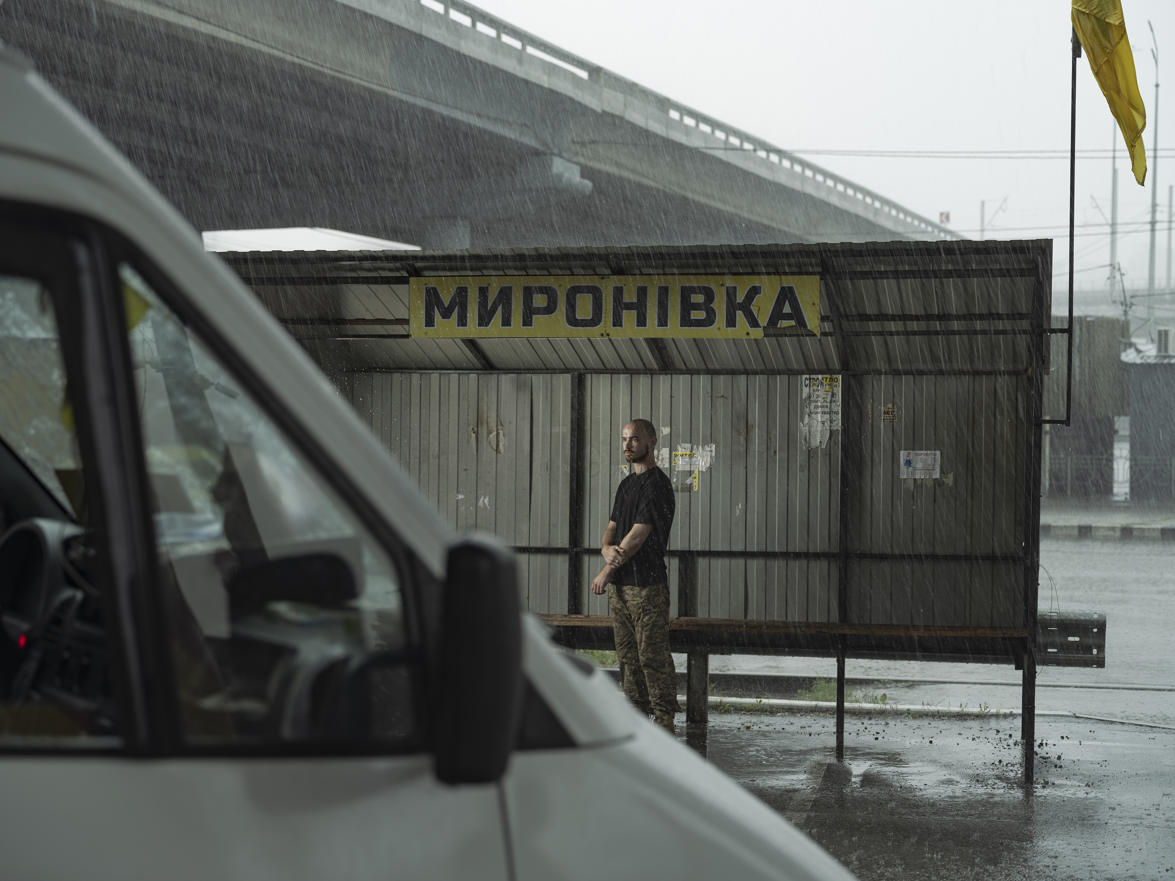 Man standing at a bus stop in Mironivka