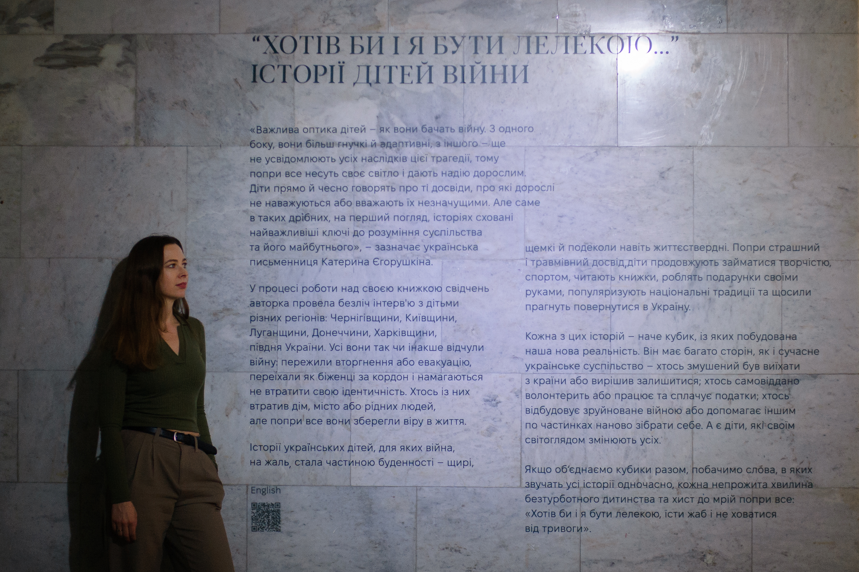 Woman in front of wall with text