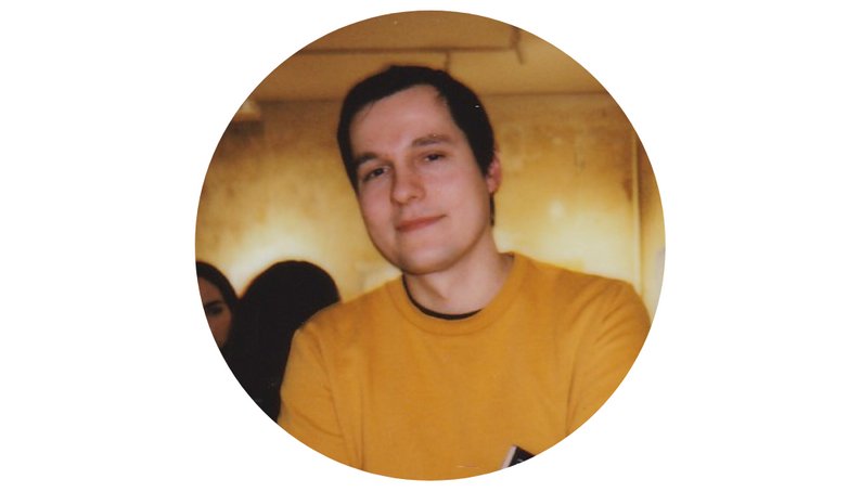 An image of a man in an orange sweater