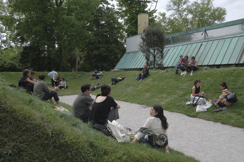 People relaxing outside next to a building