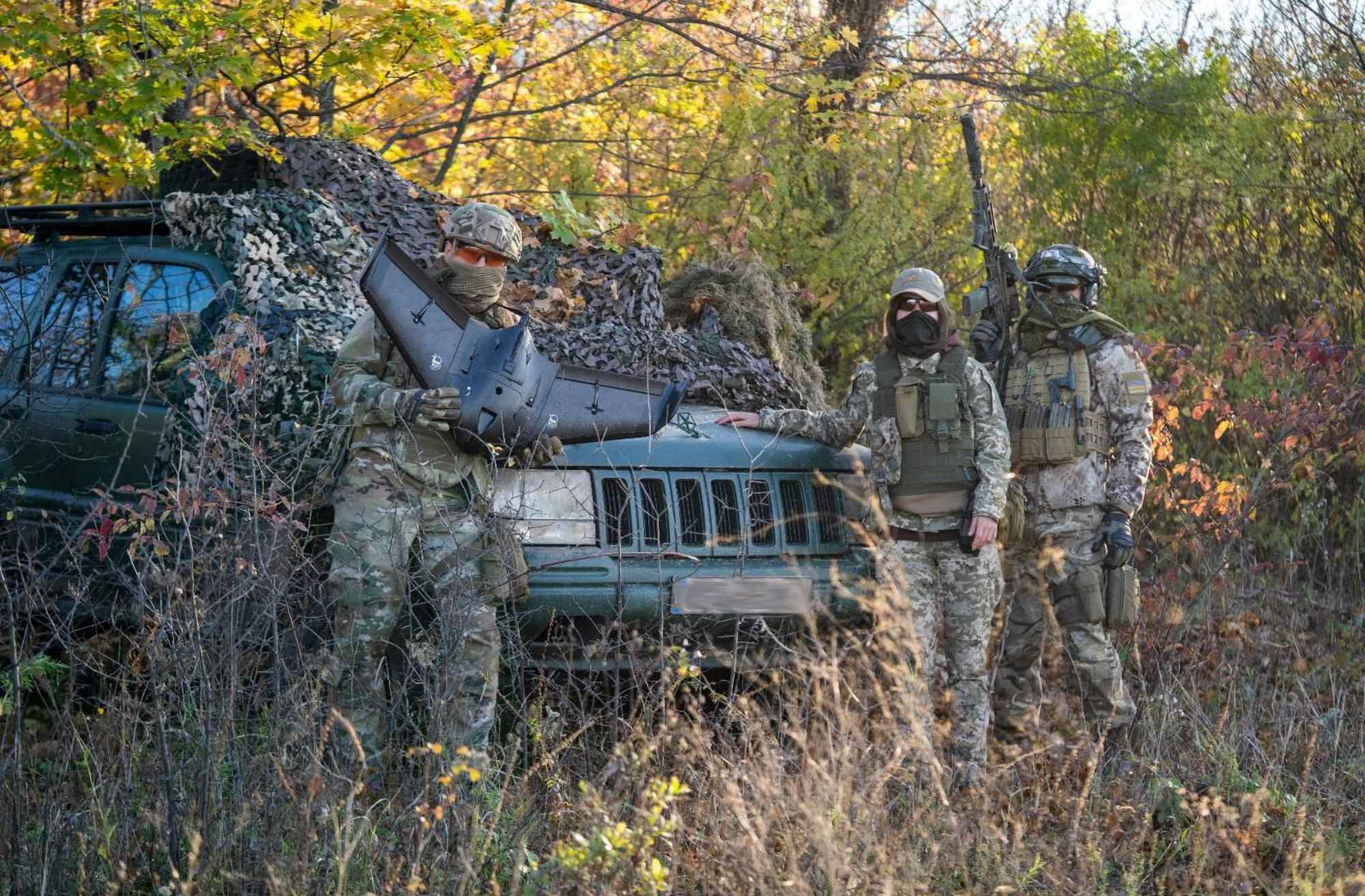 An air reconnaissance group in east Ukraine pose for a photo with an SUV supplied by Solidarity Collectives. 