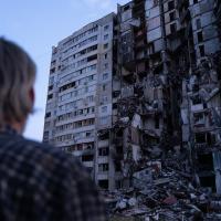 person looking at destroyed building