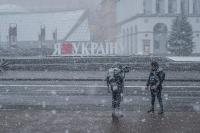 Two reporters standing in front of a "I Love Ukraine" sign